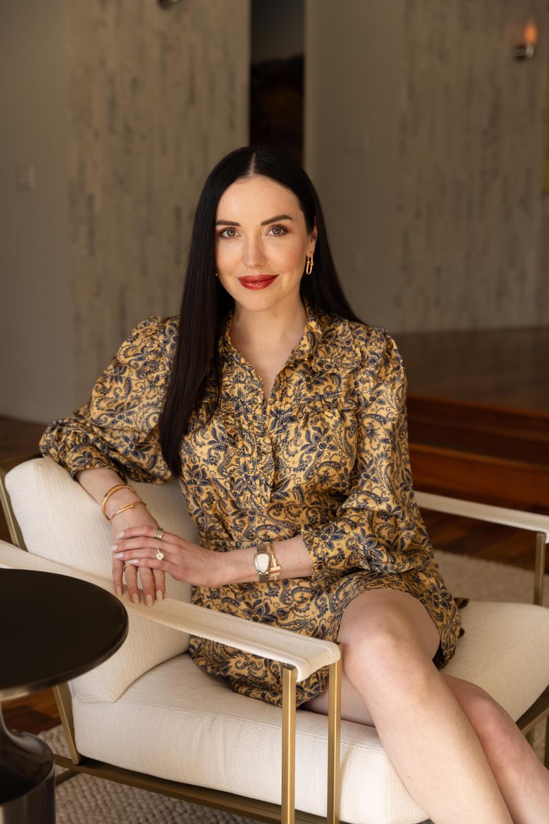 Lia Snisarenko seated in an interior hung with artwork